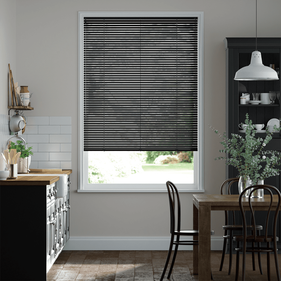 Many people wonder how to clean Venetian blinds, and in this article we'll show you. Image shows black Venetian blinds near a dining table.