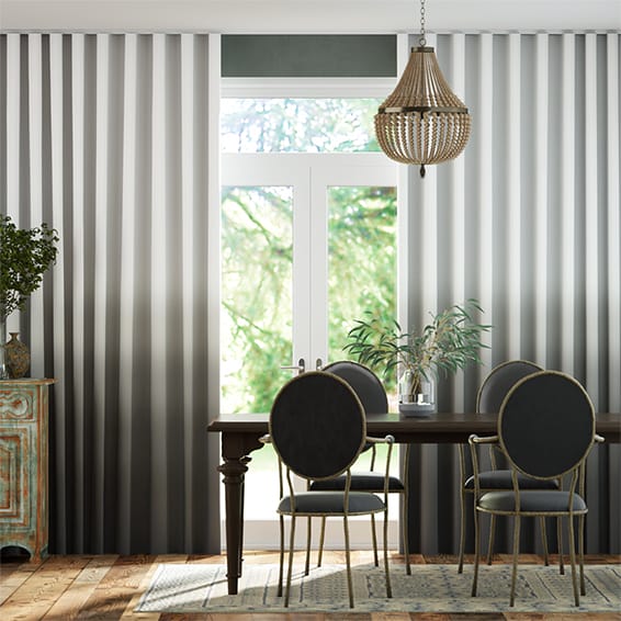 Image shows a dining room interior with floor to ceiling blockout s-fold curtains in an ombre grey to white.
