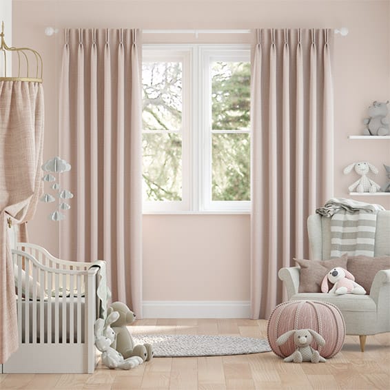 Pink curtains with a double pinch pleat heading, shown in a nursery interior. 