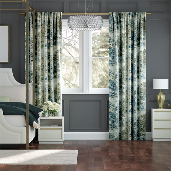 Bedroom interior showing pencil pleat curtains in a printed fabric. 